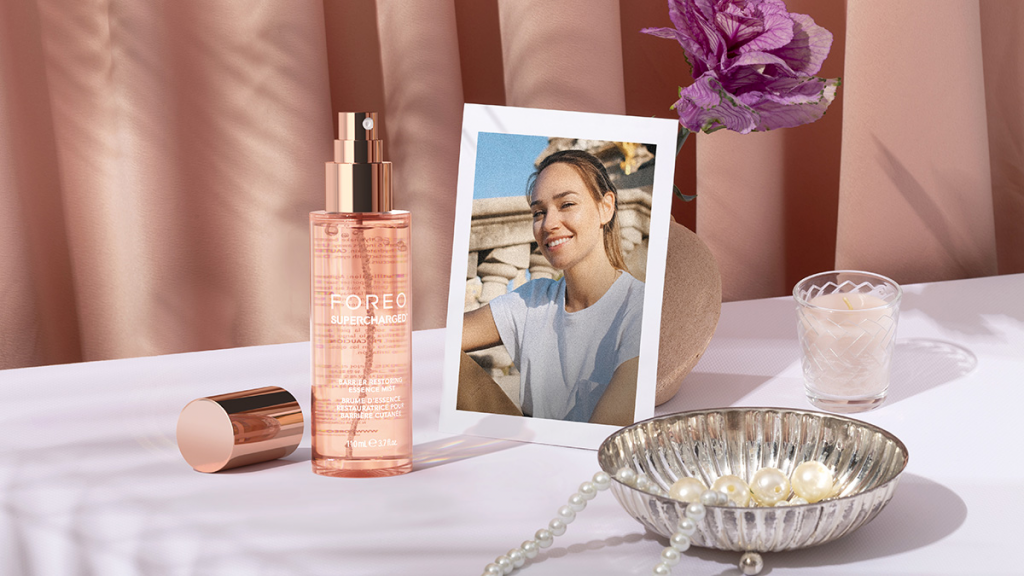 5 saveta za negu kože tokom putovanja: Kako da blistate u pokretu 19 FOREO SUPERCHARGED™ Barrier Restoring Essence Mist na stolu pored slike i cveca